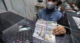 Karyawan menunjukkan uang pecahan dolar Amerika Serikat (AS) di salah satu gerai penukaran mata uang asing, Jakarta, Rabu (5/5/2026). Bank Indonesia (BI) resmi akan memperketat pembatasan pembelian dolar AS tanpa dokumen pendukung (underlying). (Kapanlagi.com/Budy Santoso)