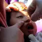 Petugas Puskesmas meneteskan vaksin polio kepada balita saat Sub-Pekan Imunisasi Nasional (PIN) Polio di Posyandu Teratai, Jalan Jawa, Depok, Jawa Barat, Senin (3/4/2023). (merdeka.com/Arie Basuki)