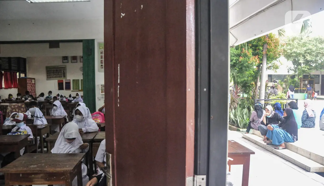 Orang tua murid saat menunggu anaknya mengikuti MPLS di SD Negeri Jati 06 Pagi, Pulogadung, Jakarta Timur, Senin (11/7/2022). Dinas Pendidikan Dan Kebudayaan Provinsi DKI Jakarta memulai Tahun Ajaran Baru 2022/2023 pada hari ini secara Pembelajaran Tatap Muka (PTM) 100 persen. (merdeka.com/Iqbal S. Nugroho)