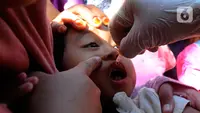 Petugas Puskesmas meneteskan vaksin polio kepada balita saat Sub-Pekan Imunisasi Nasional (PIN) Polio di Posyandu Teratai, Jalan Jawa, Depok, Jawa Barat, Senin (3/4/2023). (merdeka.com/Arie Basuki)
