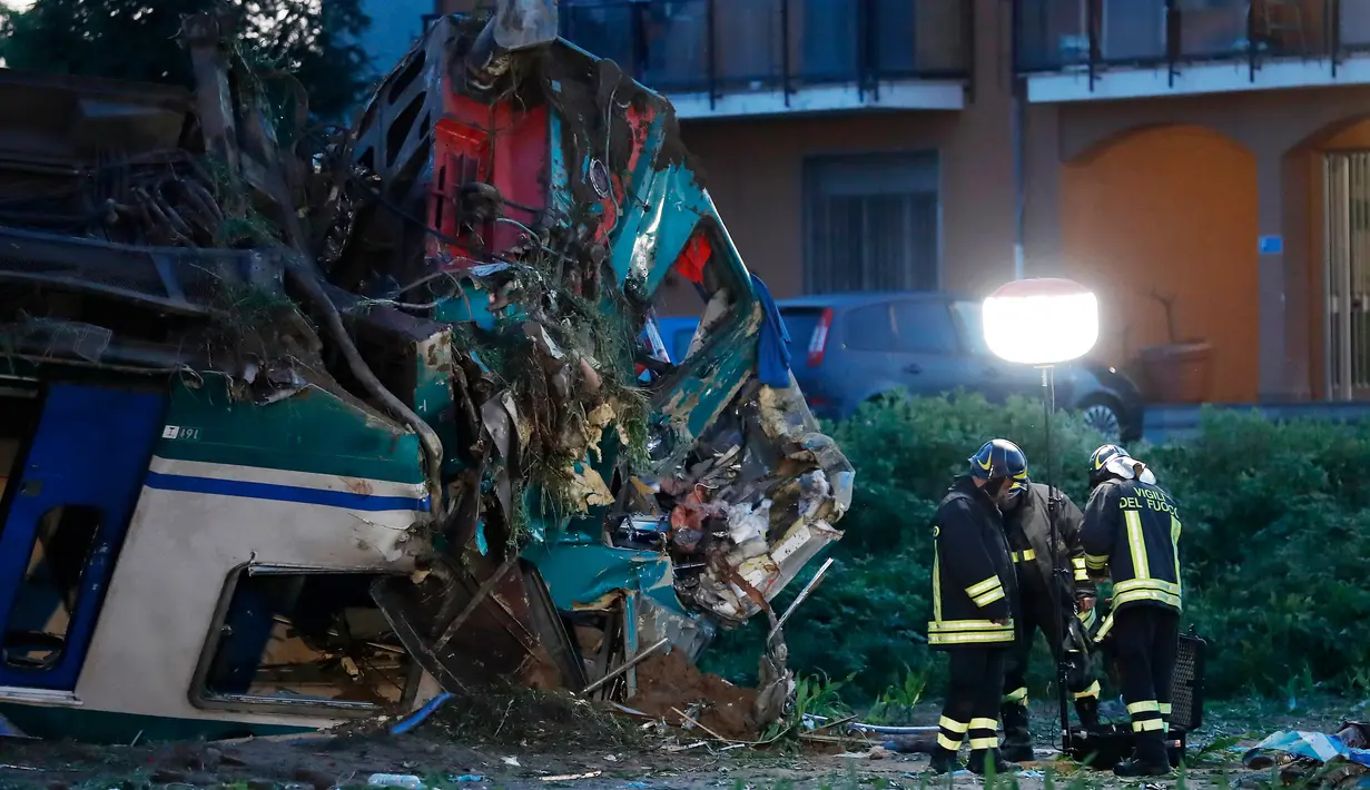 Petugas pemadam memeriksa kondisi kereta api yang menabrak sebuah truk di dekat wilayah Turin, Italia, Kamis (24/5). Salah satu dari dua korban luka kritis meninggal setelah dirawat di rumah sakit. (AP/Antonio Calanni)