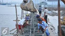 Sejumlah pekerja menyelesaikan proyek pembangunan tanggul di Pantai Muara Baru, Jakarta, Rabu (2/12). Pembangun proyek ini dilakukan di garis bibir pantai sepanjang 32 kilometer. (Liputan6.com/Gempur M Surya)