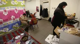 Menteri Urusan Sosial Lebanon, Haneen Sayed, mengatakan pada 7 Maret 2026, terdapat sekitar 517.000 orang telah terdaftar sebagai pengungsi di platform bantuan pemerintah. Tampak dalam foto, seorang perempuan pengungsi yang tinggal bersama keluarganya di ruang kelas sekolah, setelah melarikan diri dari serangan udara Israel di pinggiran selatan Beirut, Lebanon, duduk untuk berbuka puasa bersama, pada 7 Maret 2026. (Ibrahim AMRO/AFP)