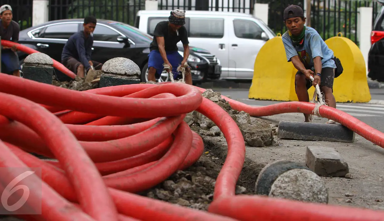 Pekerja harian lepas mengerjakan proyek pemasangan instalasi listrik bawah tanah di Jakarta, Jumat (28/10). Upah layak para buruh lepas di DKI Jakarta masih terlihat kecil dan sangat memprihatinkan. (Liputan6.com/Angga Yuniar)