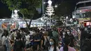 Pejalan kaki menyeberang jalan yang didekorasi dengan lampu Natal di distrik perbelanjaan Orchard road di Singapura, Selasa (8/12/2020). Mengusung tema Love This Christmas, acara tahun ini lebih sunyi karena aktivitas jalanan dibatasi di tengah pandemi Covid-19. (ROSLAN RAHMAN / AFP)