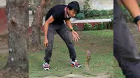 Rizki Ahmat saat bersama ular king cobra di Taman Tugu Soekarno, sebelum dipatuk ular peliharaannya di Bundaran Besar, Kota Palangkaraya, Kalimantan Tengah, Minggu pagi, 7 Juli 2018. (Dok. Kalteng Post/Jawa Pos Group)