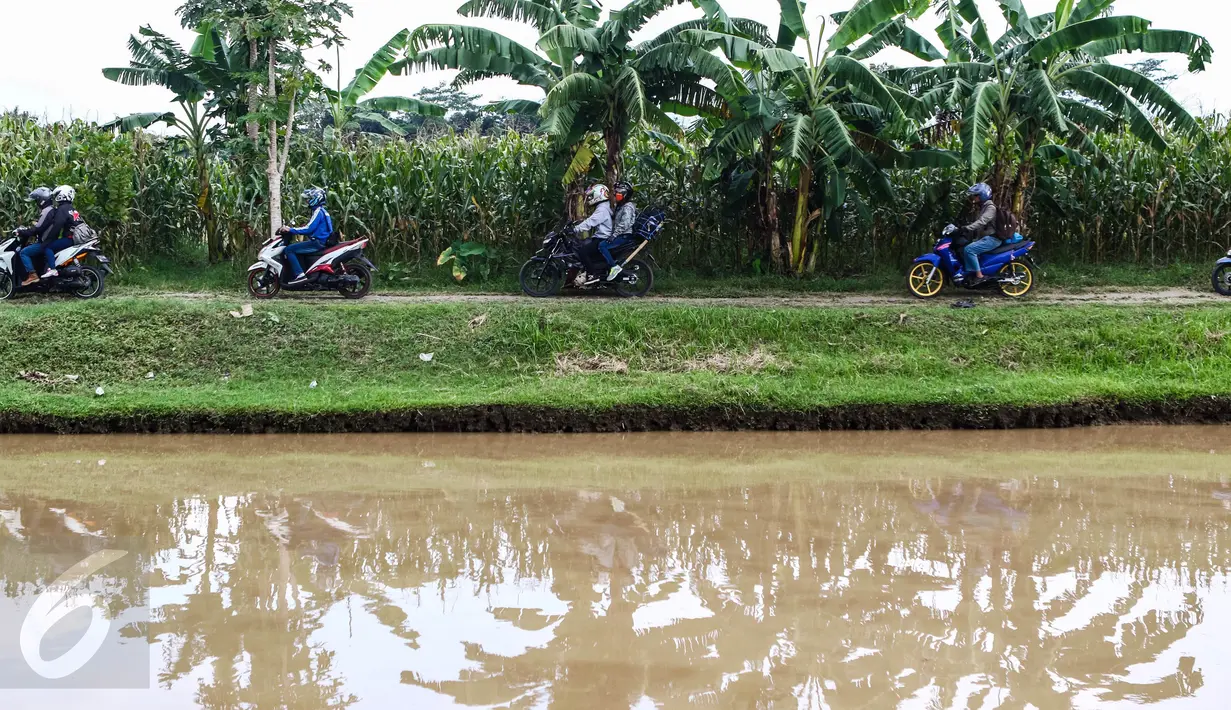 Sejumlah pemudik motor menerobos jalan perkampungan untuk mengindari kemacetan panjang di kawasan Ketanggungan, Kabupaten Brebes, Jateng, Senin (4/6). Mereka melintas di jalan yang berkelok dan terjal agar bisa sampai tujuan. (Liputan6.com/Fery Pradolo)