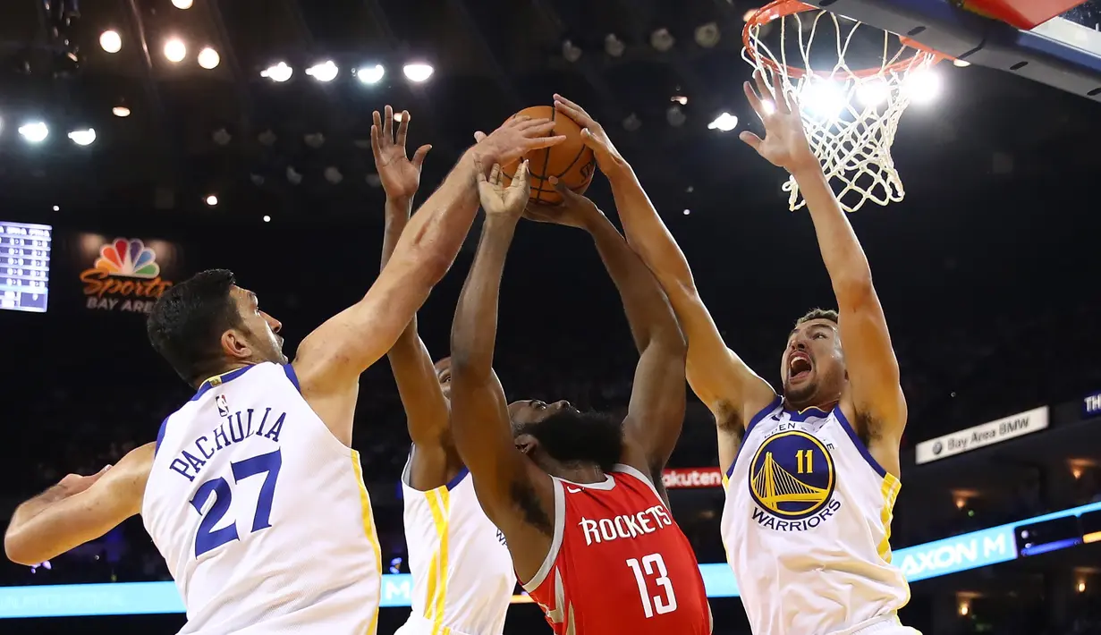 Pebasket Houston, James Harden #13 berusaha memasukan bola saat diadang para pebasket Warriors pada laga perdana NBA 2017 di Oracle Arena, Oakland, (17/10/2017).  Rockets menang 122-121.   Rockets menang 122-121. (Ezra Shaw/Getty Images/AFP)