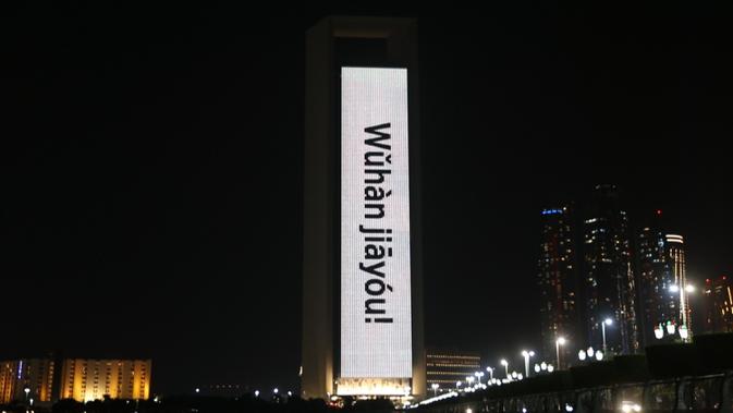 Bangunan Perusahaan Minyak Nasional Abu Dhabi (ADNOC) diterangi dengan slogan-slogan 'Wuhan jiayou' yang berarti 'Wuhan, semangat' di Abu Dhabi, Uni Emirat Arab (UEA), Minggu (2/2/2020). Hal tersebut untuk memberi semangat kepada China dalam perang melawan virus corona. (Xinhua/WAM)