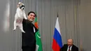 Presiden Turkmenistan Gurbanguly Berdimuhamedov menunjukkan anjing gembala Turkmen atau dikenal sebagai Alabai sebelum diberikan ke Presiden Rusia, Vladimir Putin saat pertemuan di Sochi, Rusia (11/10). (AFP Photo/Pool/Maxim Shemetov)