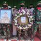 Prajurit TNI memegang foto dan karangan bunga di depan peti jenazah Pelda Anumerta Rama Wahyudi. (Liputan6.com/M Syukur)