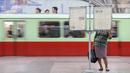 Seorang komuter membaca koran pada platform stasiun kereta bawah tanah atau metro Pyongyang, 6 September 2018. Di stasiun kereta bawah tanah ini tidak terlihatnya iklan laiknya stasiun pada umumnya. (AFP / Ed JONES)