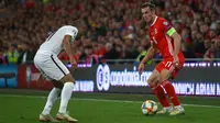 Gelandang Wales, Gareth Bale, berusaha melewati bek Azerbaijan, Pavlo Pashayev, pada laga Kualifikasi Piala Eropa 2020 di Cardiff City Stadium, Cardiff, Jumat (6/9). Wales menang 2-1 atas Azerbaijan. (AFP/Geoff Caddick)