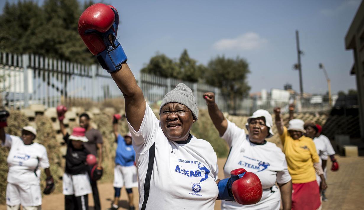 Para nenek pemanasan sebelum latihan tinju pada Boxing Gogos di Cosmo City, Johannesburg, Selasa (19/9/2017). Berkat latihan rutin yang dipimpin Claude Maphosa ini para lansia berhasil sembuh dari penyakit dan hidup lebih sehat. (AFP/Gulshan Khan) 