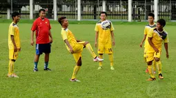 Asisten pelatih Timnas Myanmar U19, Nyi Nyi Latt (berbaju merah) terlihat mengawasi langsung sesi latihan anak didiknya di lapangan C Senayan Jakarta, Minggu (4/5/2014). (Liputan6.com/Helmi Fithriansyah)