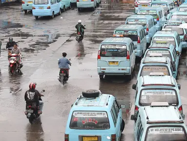 Pengendara sepeda motor melintasi jalur angkutan umum di Terminal Kampung Melayu, Jakarta, Rabu (6/2). Meskipun terdapat larangan melintas bagi pemotor, namun masih ada sejumlah pengendara nekat menerobos masuk terminal. (Liputan6.com/Immanuel Antonius)