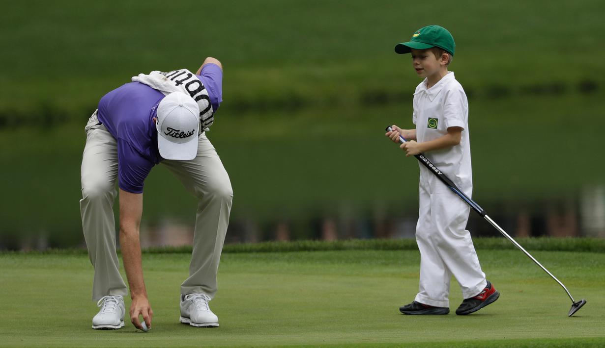 Pegolf Webb Simpson bersama anaknya  James Simpson saat mengikuti acara Masters Par 3 Tournament di Augusta National Golf Club, Georgia, (5/4). Anak-Anak ini menunjukkan keterampilannya bermain golf bersama orang tuanya. (AP Photo/David J. Phillip)