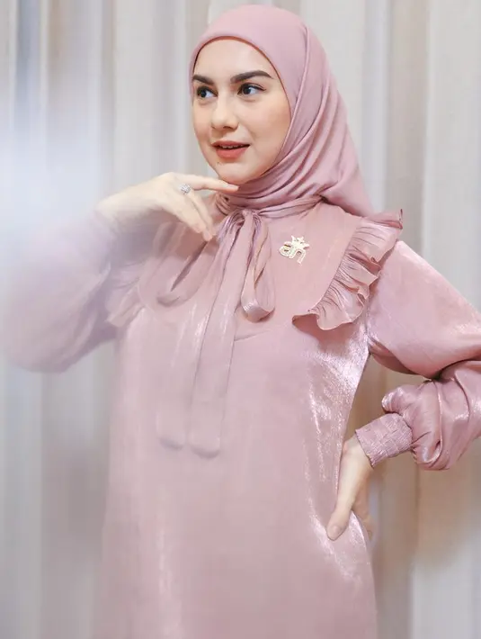 Dress tersebut memiliki aksen pita di bagian leher dengan ruffle di bagian dada dan bross keemasan. Lengan pump dengan karet di bagian bawah. [@_irishbella_]