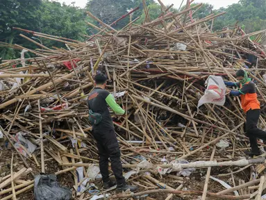 Petugas sedang memilah tumpukan bambu bekas sisa alat peraga kampanye di tempat penyaringan sampah di TB Simatupang, Jakarta, Jumat (16/2/2024). (Liputan6.com/Herman Zakharia)