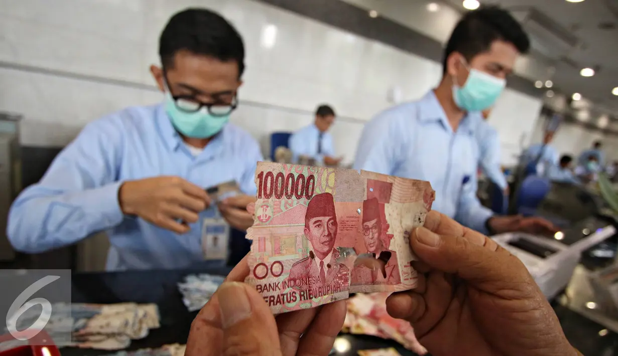 Petugas mengecek uang rusak yang ditukarkan di Bank Indonesia, Jakarta, Senin (6/6). Syarat penukaran uang meliputi keaslian uang, masih terdapat nomor seri, dan masih tersisa minimal 2/3 bagian dari bentuk uang. (Liputan6.com/Immanue Antonius)