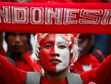 Seorang suporter Indonesia menunjukkan syal untuk mendukung timnas Indonesia U-22 sebelum pertandingan melawan Thailand selama Asian Games Tenggara di Shah Alam, Malaysia, Selasa, (15/8). (AP Photo / Vincent Thian)