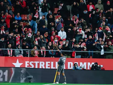 Pemain Real Madrid, Jude Bellingham, melakukan selebrasi di depan suporter Girona pada laga pekan ke-16 Liga Spanyol di Stadion Montilivi pada Sabtu (7/12/2024). (AP Photo/Joan Monfort)