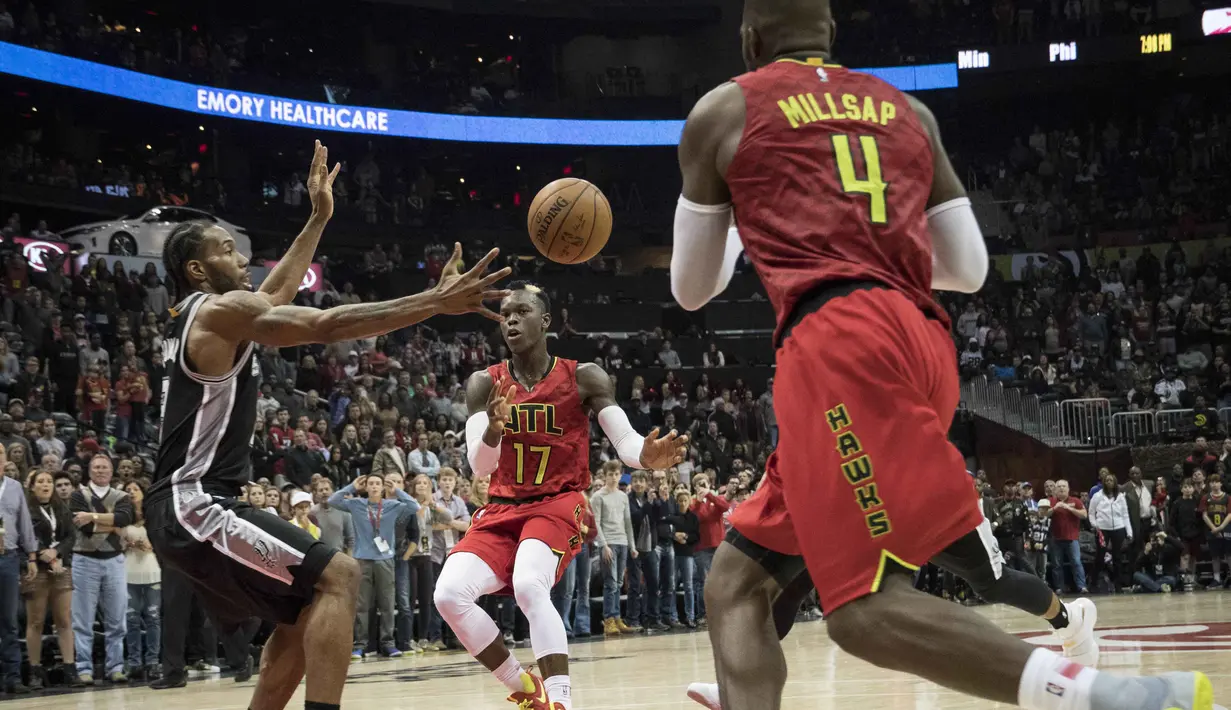 Aksi pemain Atlanta Hawks, Dennis Schroder (tengah) mengecoh pemain Spurs, Kawhi Leonard (kiri) pada lanjutan NBA basketball game di Philips Arena, (01/01/2017). Atlanta menang 114-112. (AP/John Amis)
