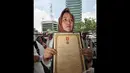 Seorang wanita dari keluarga veteran membawa piagam bintang gerilya saat melakukan unjuk rasa di depan Gedung KPK, Jakarta, Kamis (18/12/2014). (Liputan6.com/Miftahul Hayat)