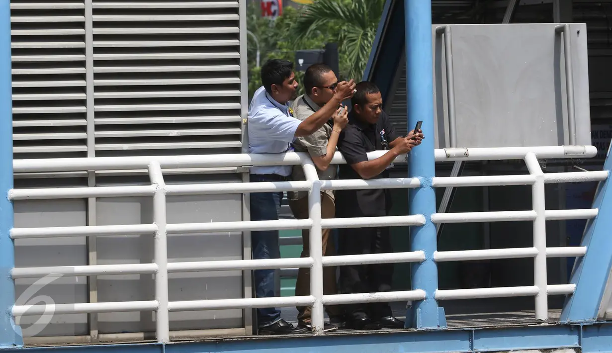 Pekerja memfoto dengan kamera ponsel rombongan Raja Salman bin Abdulaziz al-Saud saat melintas di Jalan MH Thamrin, Jakarta, Kamis (2/3). Agenda Raja Salman dimulai dari kunjungan ke gedung MPR/DPR, Masjid Istiqlal. (Liputan6.com/Immanuel Antonius) 