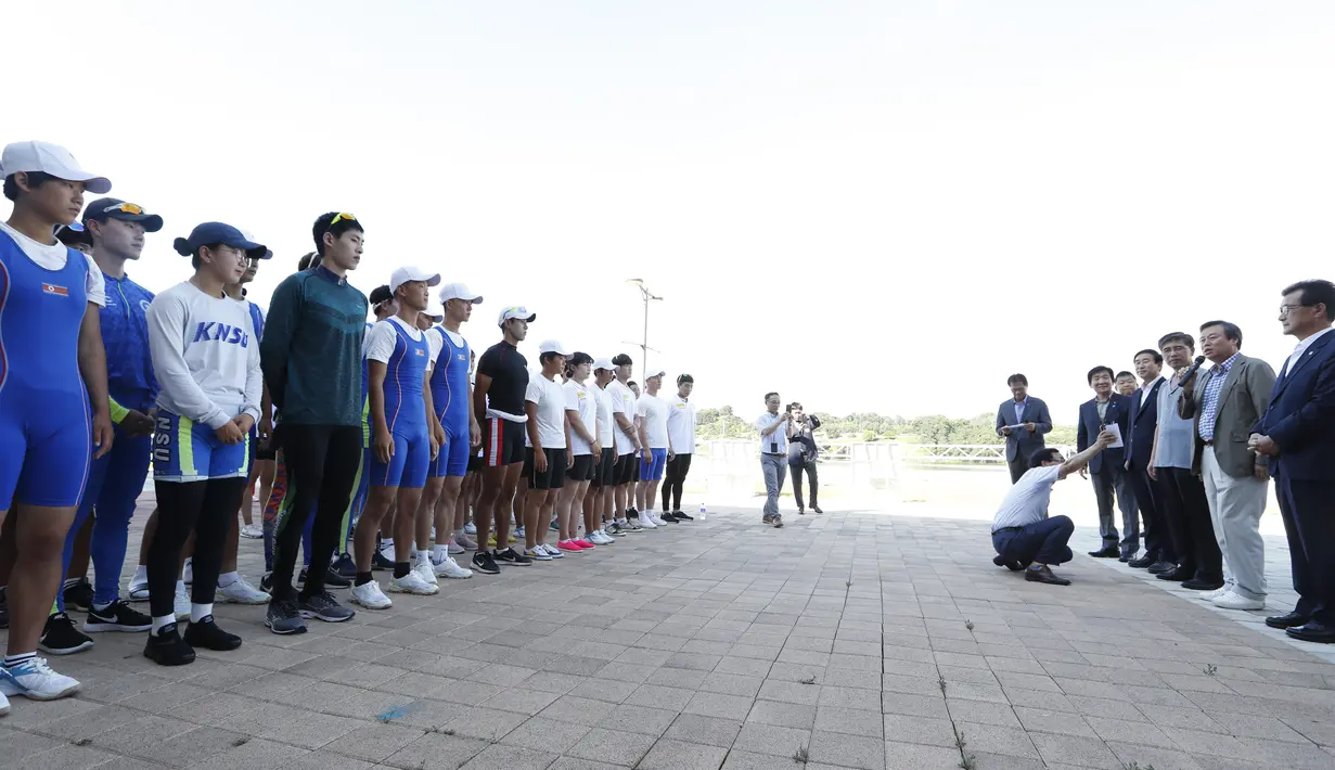 Menteri Olahraga dan Kebudayaan Korsel Do Jong-hwan (dua kanan) berbicara kepada atlet Korsel dan Korut sebelum latihan bersama jelang Asian Games 2018 di Tangeum Lake International Rowing Center, Chungju, Korsel, Selasa (31/7). (Jeon Heon-Kyun/Pool/AFP)