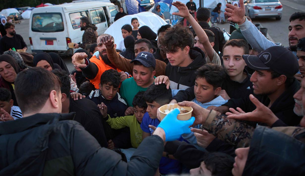 Dalam sebulan terakhir, Israel juga memerintahkan warga Lebanon untuk mengevakuasi diri. Pengeboman dan desakan evakuasi memaksa warga Lebanon meninggalkan rumah mereka. Tampak dalam foto, para pengungsi menunggu untuk menerima makanan sumbangan di samping tenda-tenda yang mereka gunakan sebagai tempat berlindung setelah melarikan diri dari serangan udara Israel di Lebanon selatan, Beirut, Lebanon, Senin 6 April 2026. (AP Photo/Emilio Morenatti)