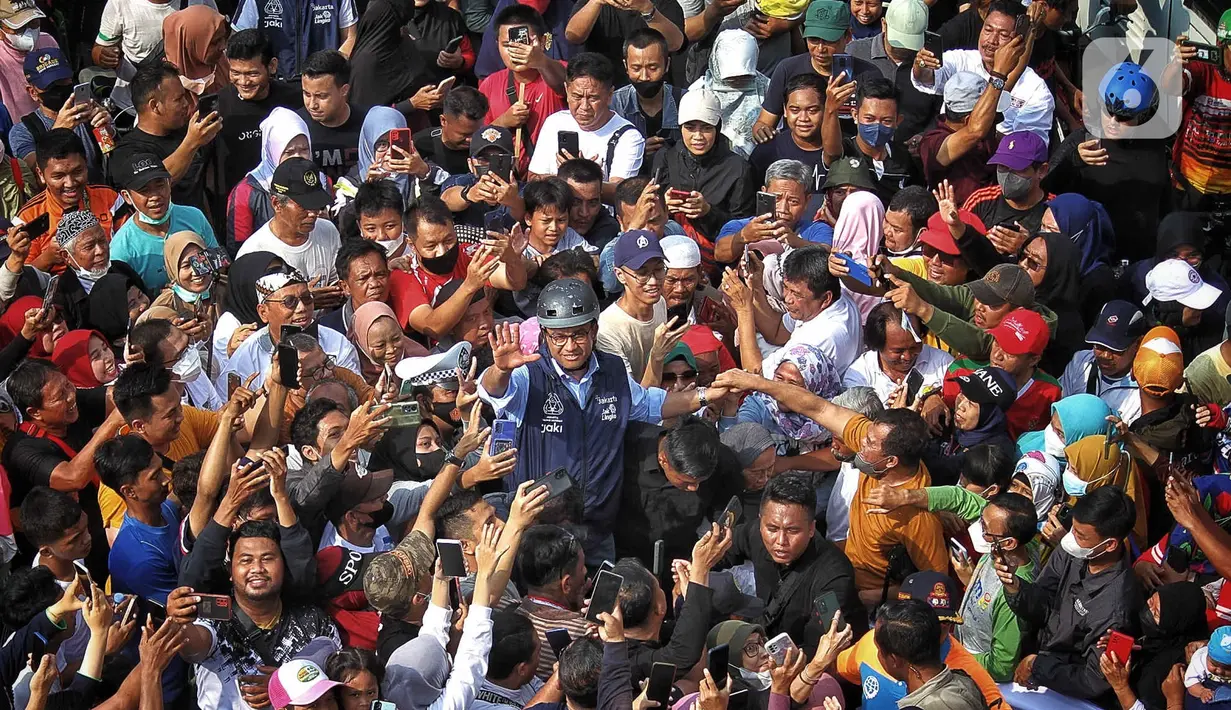 Gubernur DKI Jakarta Anies Baswedan menyapa warga yang tengah melakukan CFD di Bundaran HI, Jakarta, Minggu (16/10/2022). Anies berkeliling menggunakan sepeda menuju Balai Kota sambil menyapa warga Jakarta di hari terakhirnya menjabat sebagai DKI 1. (Liputan6.com/Angga Yuniar)