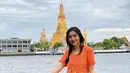 Berlibur ke Bangkok, Febby tampil mengenakan kebaya kutu baru warna orange dipadukan kain batik biru yang dijadikan skirt. [Instagram/@febbyrastanty]
