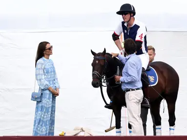 Putri Wales dari Inggris, Kate Middleton berbincang dengan suaminya Pangeran Inggris William sebelum bermain Polo dalam pertandingan The Royal Charity Polo Cup 2023 di Guards Polo Club di Windsor, barat London pada 6 Juli 2023. (AFP/Henry Nicholls)