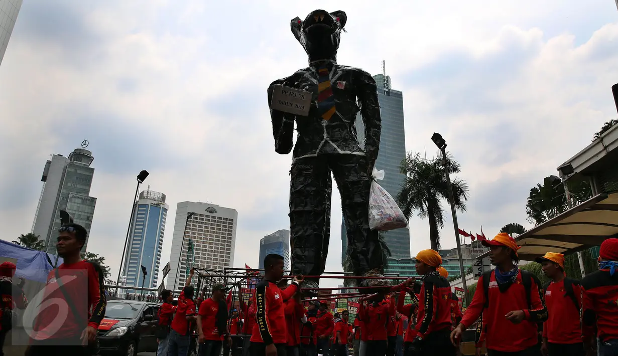Para buruh membawa simbol tikus raksasa saat aksi unjuk rasa menuju Istana Negara, Jakarta (31/10). Buruh meminta pemerintah mencabut PP Nomor 78 soal pengupahan yang dinilai tidak memperhatikan kesejahteraan para buruh. (Liputan6.com/Johan Tallo)
