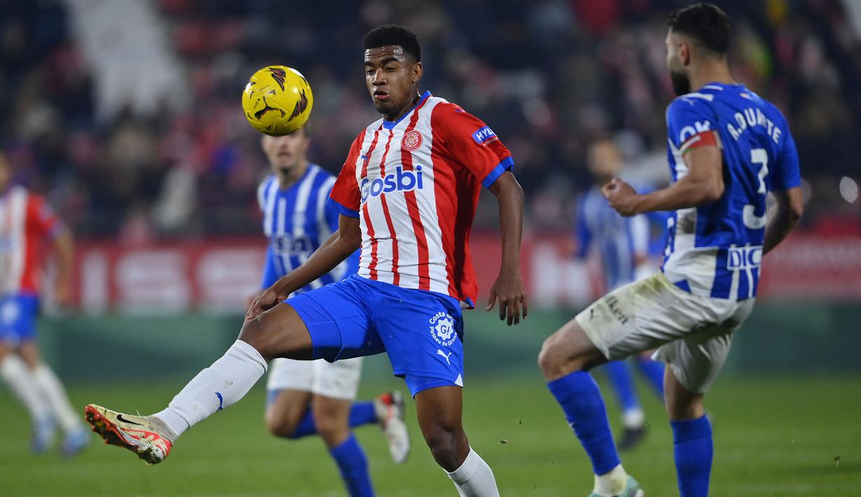 Gelandang Girona, Jhon Solis (kiri) mengontrol bola di depan bek Alaves, Ruben Duarte pada laga pekan ke-17 Liga Spanyol 2023/2024 di Montilivi Stadium, Girona, Selasa (19/12/2023) dini hari WIB. (AFP/Pau Barrena)
