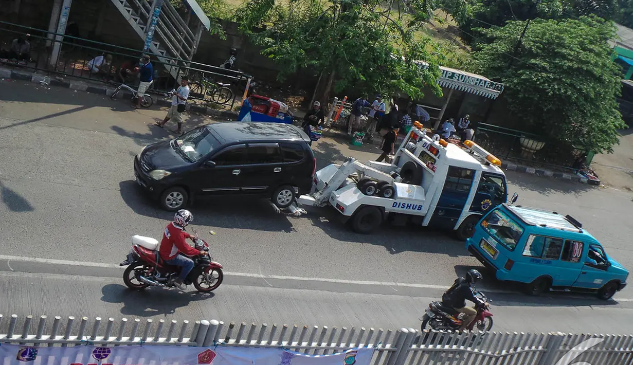 Kendaraan yang terparkir liar diderek Petugas Dishub di kawasan Jatinegara, Jakarta, Senin (8/9/2014) (Liputan6.com/Faizal Fanani)