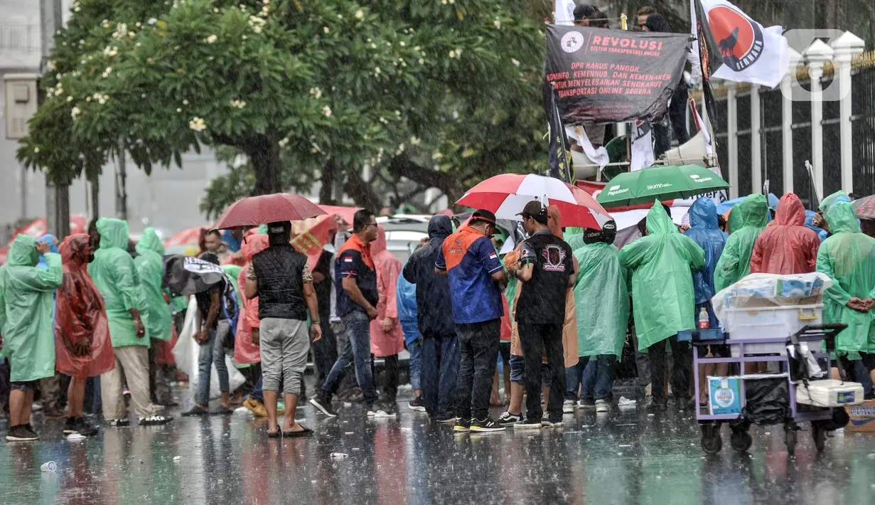 Pengemudi taksi dan ojek online menggelar aksi di depan Gedung DPR RI, Jakarta, Rabu (21/9/2022). Puluhan massa tersebut menuntut pemerintah membuat payung hukum bagi mitra pengemudi online, menaikkan tarif dasar, menyetarakan potongan menjadi 10 persen, dan meminta subsidi asuransi kesehatan. (merdeka.com/Iqbal S. Nugroho)