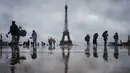 <p>Pengunjung berjalan di Esplanade du Trocadero dengan latar belakang Menara Eiffel, yang ditutup untuk umum pada hari keempat pemogokan stafnya, di Paris pada 22 Februari 2024. (Dimitar DILKOFF/AFP)</p>