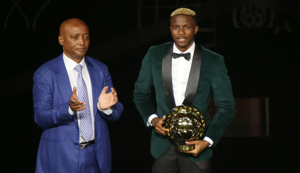 Victor Osimhen (kanan) mendapatkan penghargaan pemain terbaik Afrika 2023 dari Konfederasi Sepak Bola Afrika (CAF) pada acara yang berlangsung di Marrakesh, Maroko, Selasa 12 Desember 2023. Ia berhasil mengungguli bek kanan Paris Saint-Germain asal Maroko, Achraf Hakimi, dan penyerang Liverpool asal Mesir, Mohamed Salah. (AFP/STR)