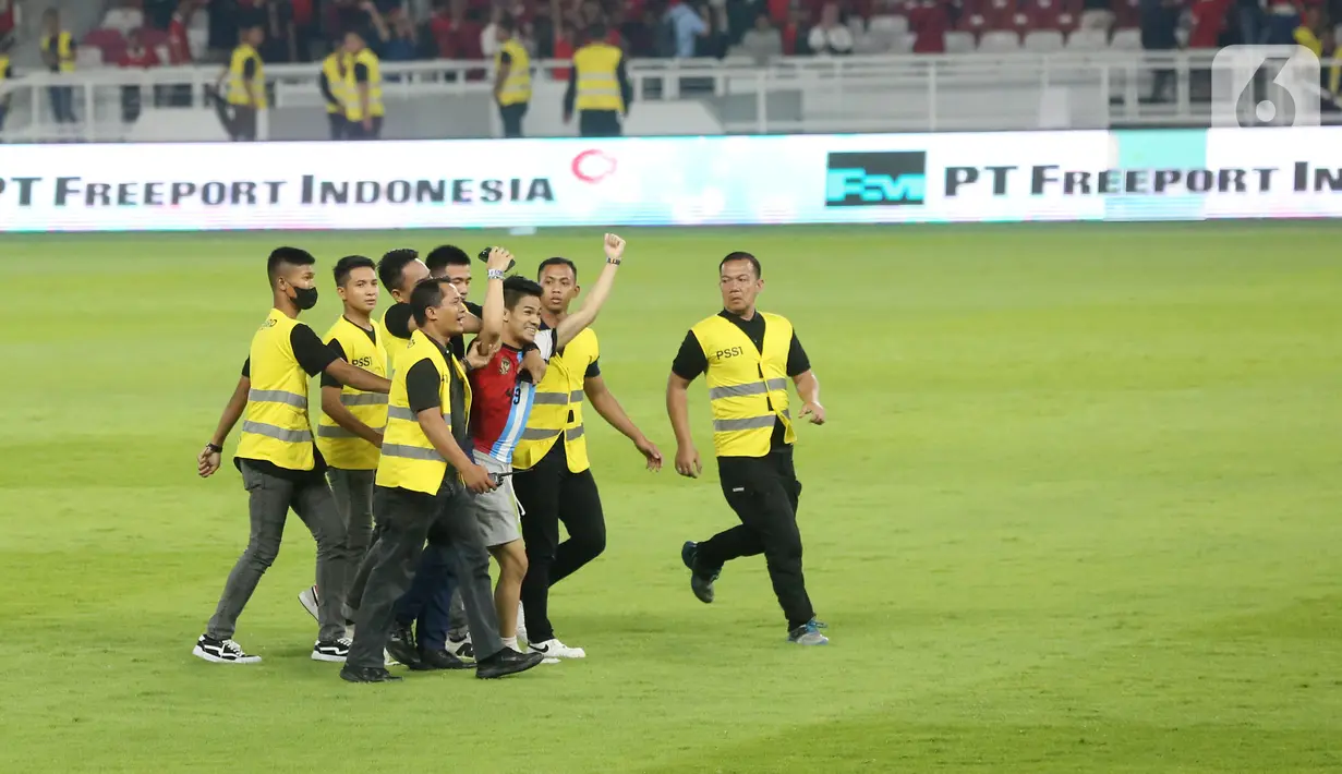 Penyusup tersebut kemudian memeluk Garnacho sembari melakukan selfie. Namun tak lama kemudian penyusup tersebut berhasil diamankan oleh petugas. (Bola.com/Muhammad Iqbal Ichsan)