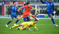 Aksi bintang Timnas China, Wu Lei (merah) saat menghadapi hadangan dari kiper Timnas Singapura, Hassan Sunny di putaran kedua Kualifikasi Piala Dunia 2026. (AFP).
