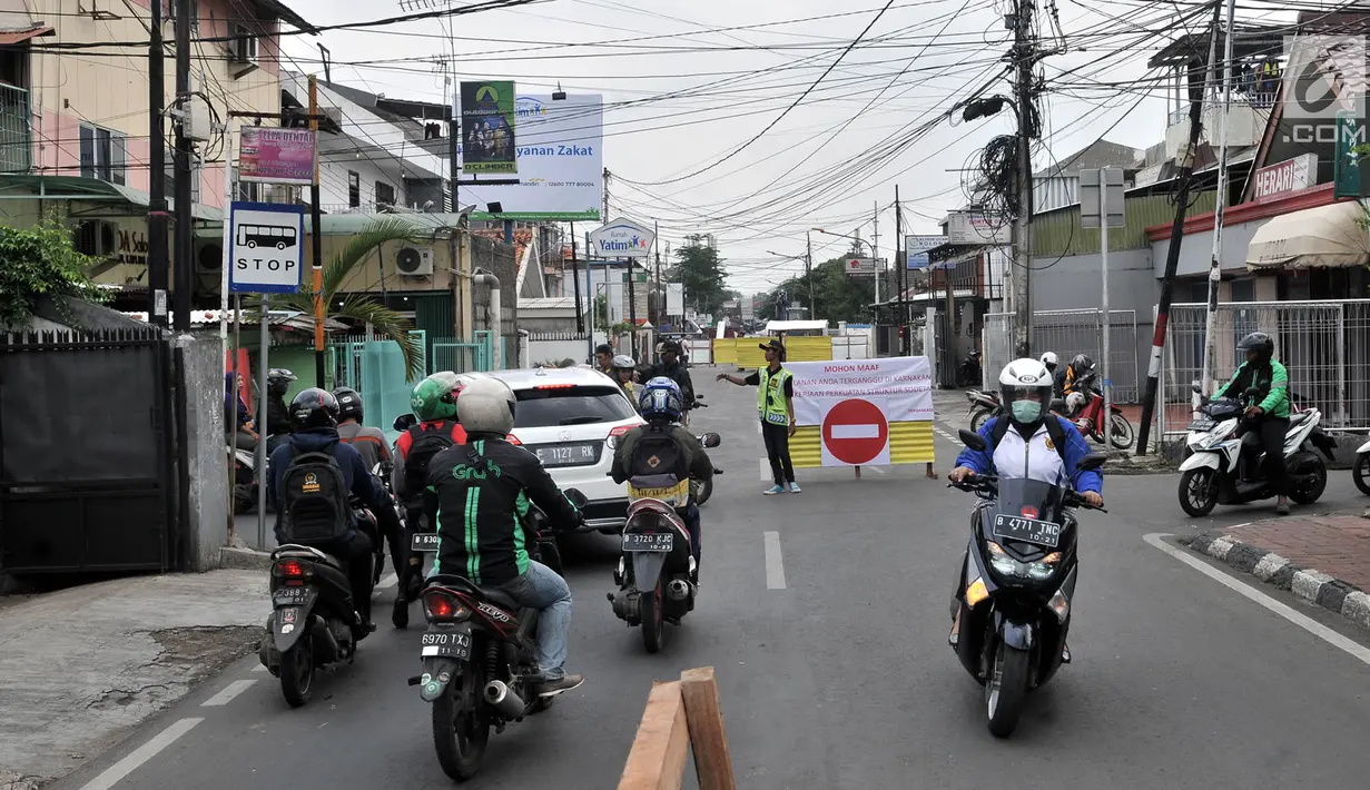 Petugas mengatur arus kendaraan saat penutupan Jalan Otista III, Jakarta, Selasa (4/12). Penutupan Jalan Otista III untuk memperlancar pengerjaan konstruksi dan penguatan terowongan pengendali banjir sodetan Kali Ciliwung. (Merdeka.com/Iqbal Nugroho)