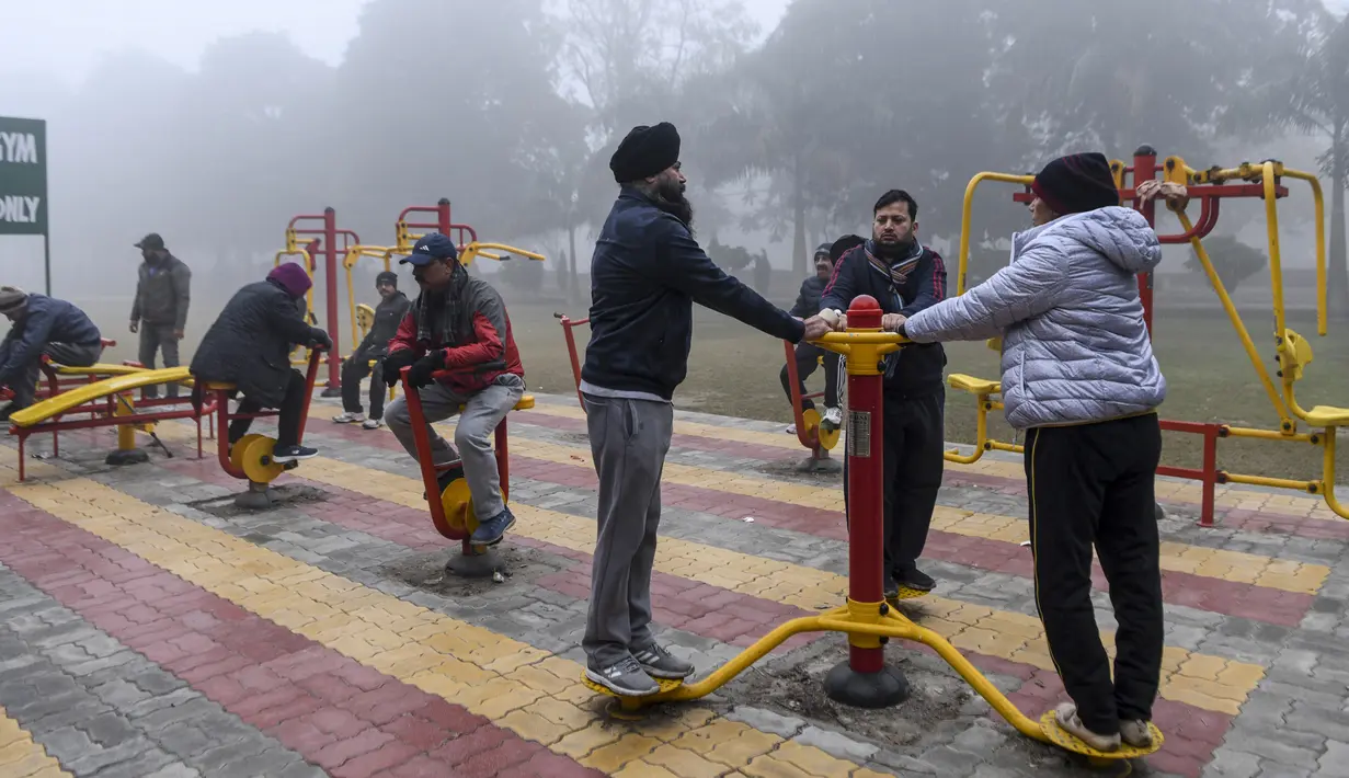 Orang-orang berolahraga di tengah kabut tebal selama hari yang dingin di sebuah taman di Amritsar, India (30/12/2019). India saat ini mengalami musim dingin dengan hari dingin terpanjang dalam 22 tahun terakhir. (AFP/Narinder Nanu)
