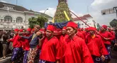 Para pengawal keraton yang dikenal secara lokal sebagai ‘abdi dalem’ membawa gunungan, sebuah persembahan berbentuk gunung dari hasil panen, selama upacara Grebeg, tradisi suci Keraton Yogyakarta pada 5 September 2025. (DEVI RAHMAN/AFP)
