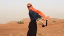 Citra Kirana di padang pasir Dubai dalam rangkaiannya melakukan umroh sekaligus liburan. Pose melompat ini seakan menunjukkan Citra Kirana terbang. (via instagram/@citraciki)
