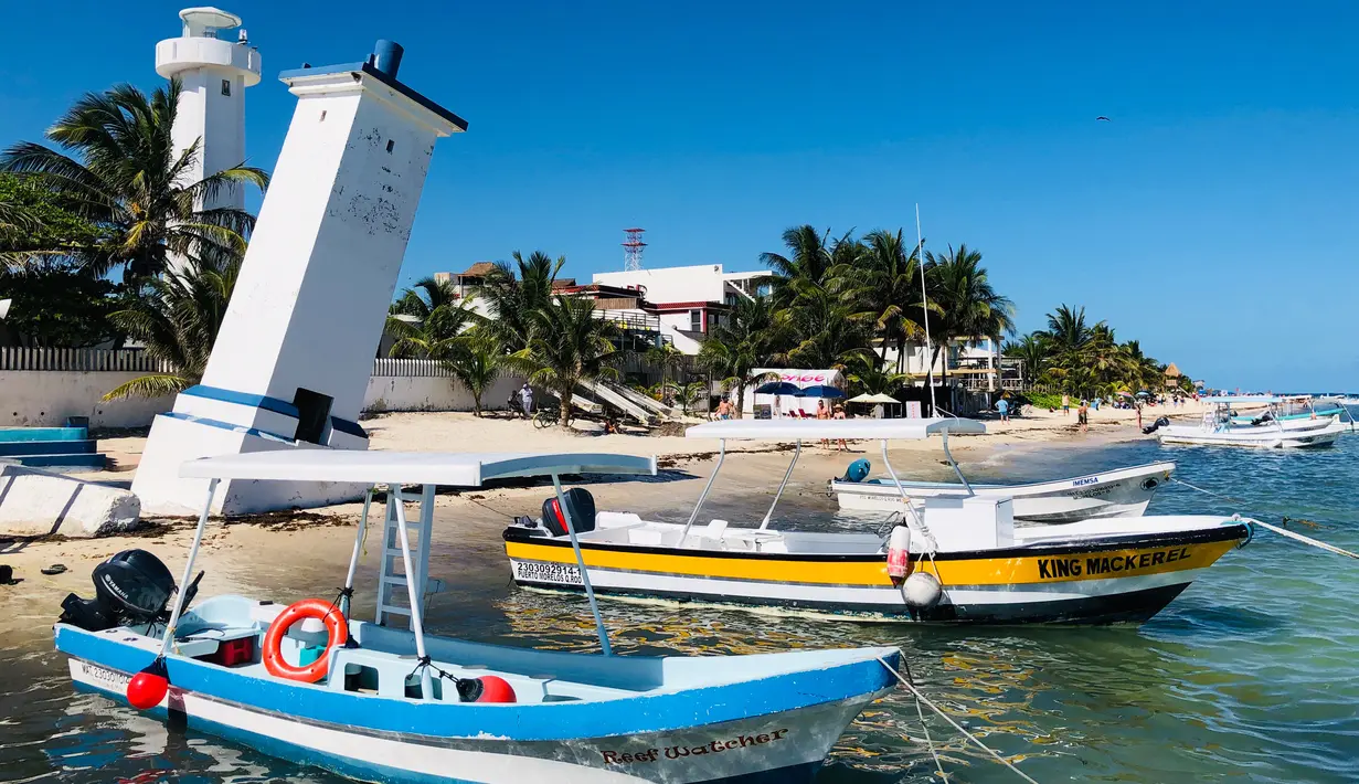 Dua kapal bersandar di pantai di Puerto Morelos, negara bagian Quintana Roo, Meksiko (14/2). Puerto Morelos bergabung dengan desa Leona Vicario pada 6 Desember 2015, untuk menjadi kota ke-11 di Quintana Roo. (AFP Photo/Daniel Slim)