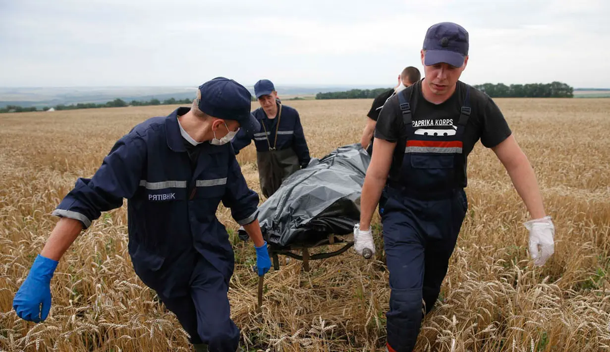 Para petugas juga membawa sisa puing untuk keperluan penyidikan. Ukraina menuduh pemberontak Rusia dan pro-Moskow menghancurkan bukti kejahatan dari sisa reruntuhan pesawat (REUTERS/Maxim Zmeyev).