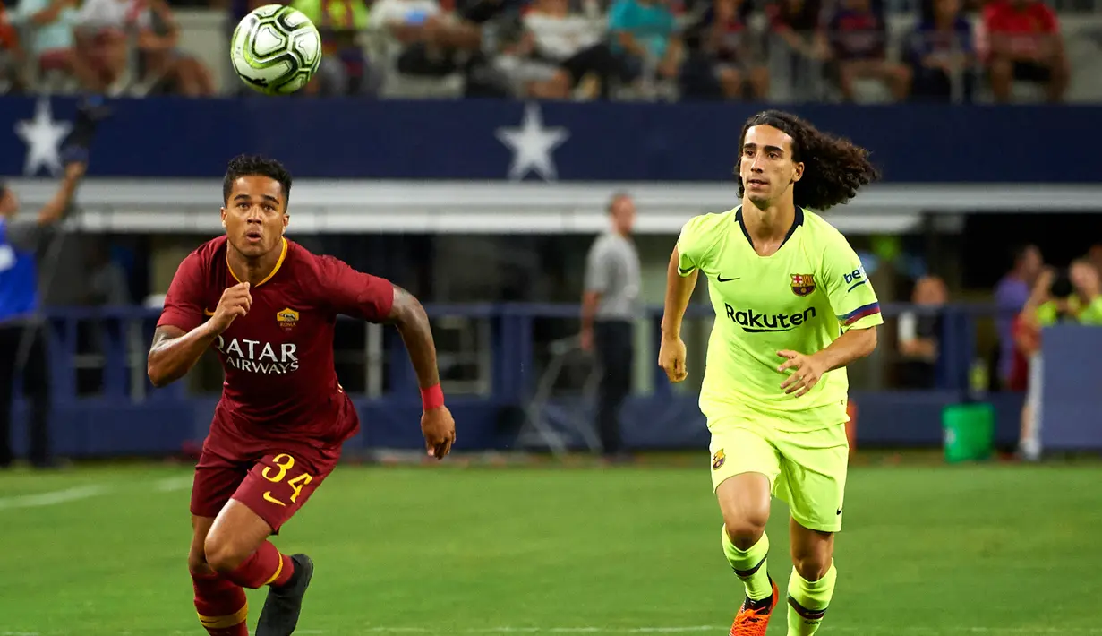Penyerang AS Roma, Justin Kluivert (kiri) berusaha mengejar bola dari kawalan pemain Barcelona Marc Cucurella saat bertanding pada ICC 2018 di AT & T Stadium di Arlington, Texas (31/7). Roma menang telak 4-2 atas Barcelona. (AFP Photo/Cooper Neill)