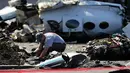Petugas investigasi mengamati reruntuhan pesawat kecil yang jatuh ke area parkir sebuah pusat perbelanjaan di Santa Ana, California, Senin (6/8). Tidak ada kebakaran dan tidak ada korban jiwa di darat. (AP/Jae C. Hong)